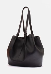 Czarna skórzana torebka typu tote o miękkim, luźnym fasonie, z dwoma długimi uchwytami i gładką fakturą. Brak widocznych elementów metalowych lub wzorów.