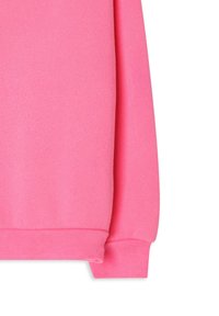 Heller pinker Sweatshirtärmel und Bündchen auf weißem Hintergrund, der die Stoffstruktur und Saumnaht hervorhebt.