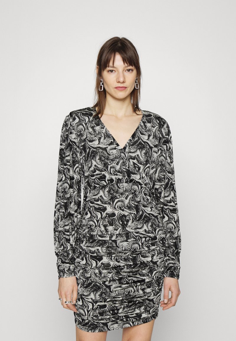 Vestido com padrão em preto e branco, com mangas longas, decote em V e textura franzida na cintura, apresentando um design em espiral por toda a peça.