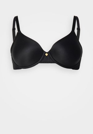 Soutien-gorge rembourré noir avec des coques lisses, des bretelles ajustables et un détail en forme de cœur doré au centre. Bande texturée en bas.