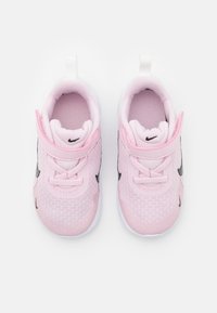 Baskets de sport en mesh rose avec des semelles blanches, arborant des accents noirs et une sangle Velcro, conçues pour le confort et le port actif.