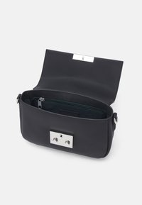 Sac à main en synthétique noir avec une forme structurée, quincaillerie en argent, poche intérieure zippée et extérieur texturé. S'ouvre avec un rabat.
