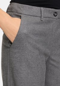 Pantalons taillés gris en tissu texturé. Dotés d'un devant plat, de poches latérales et d'une fermeture à bouton noir.