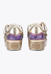 Para niskich sneakersów z metalicznymi złotymi obcasami i wielokolorowymi panelami z tkaniny, pokazana z tyłu na białym tle.