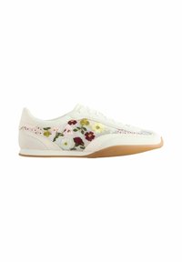 Baskets basses blanches avec des fleurs brodées multicolores et une semelle en caoutchouc beige, vue de côté sur un fond blanc.