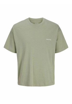 Camiseta de algodón ligera color verde oliva claro, con mangas cortas y cuello redondo, con un pequeño texto blanco "originals © 1990" en el pecho izquierdo.