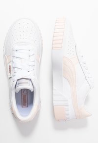 Vita sneakers med ljusrosa detaljer, tillverkade av läder och syntetiska material. Har perforerad tåsbox och kraftig gummisula.