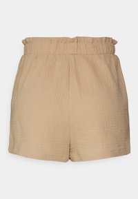 Shorts beige texturés avec une taille élastique, offrant une coupe ample et une longueur mi-cuisse. Design simple, sans poches ni ornements.