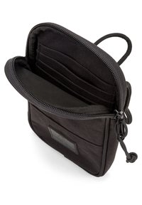 Svart tygaxelväska med dragkedjestängning, utrustad med flera kortfack, en slät insida och ett litet handtag på toppen.