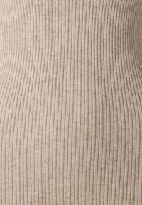 Tissu beige côtelé avec une texture douce, présentant des rayures verticales, offrant un design classique et neutre pour une utilisation polyvalente.