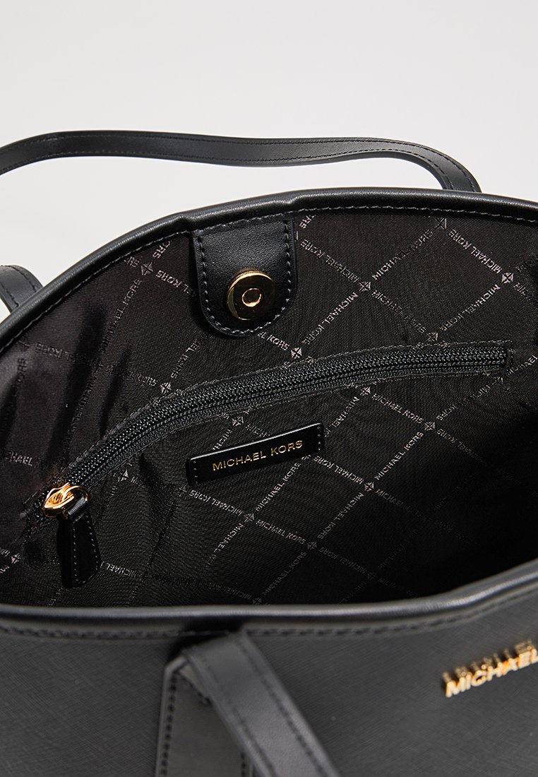 Borsa nera con esterno liscio, dotata di fodera in tessuto con un delicato motivo a logo, hardware in oro e una tasca interna con zip.