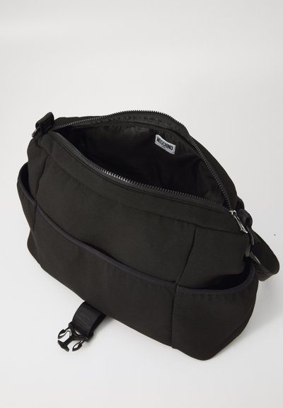 Svart Moschino axelväska med zip-försedd huvudfack, framficka, sidofack och justerbar rem med plastspänne.