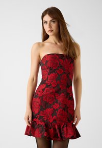 Schwarzes trägerloses Kleid mit kräftigem roten Blumenmuster, tailliertem Oberteil, ausgestelltem Volantsaum und glatter Textur.