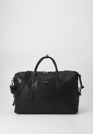 Sac de voyage en cuir noir avec poignées doubles, bandoulière détachable, fermeture éclair et logo discret. Texture lisse et design minimaliste.