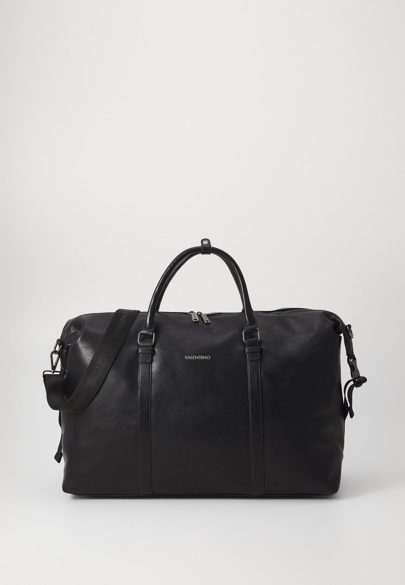 Black leather duffel bag with dual handles, detachable strap, zip closure, and subtle logo. Smooth texture and minimalist design.