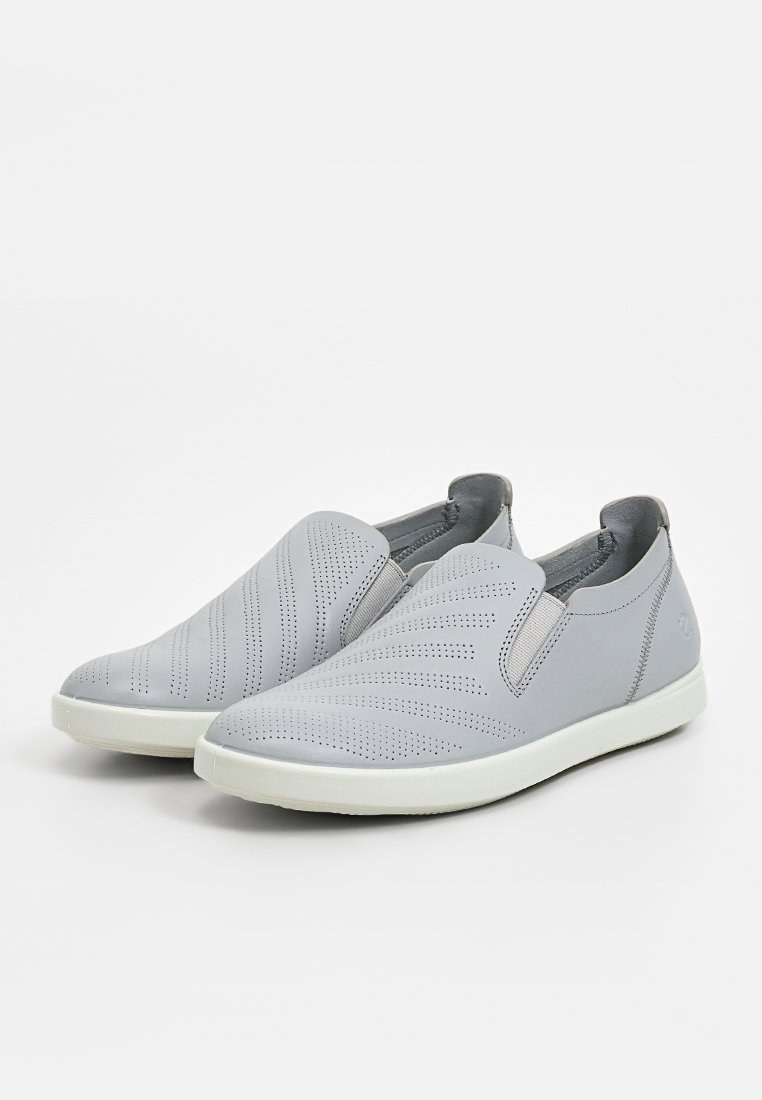 Graue Slipper aus perforiertem Leder, mit einer glatten Textur, elastischen Seitenteilen und einer weißen Gummisohle.
