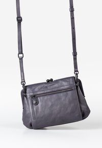 Borsa a tracolla grigia in pelle con tasca frontale con zip, tracolla regolabile e dettagli in metallo arrotondati, caratterizzata da una texture liscia e una forma compatta.