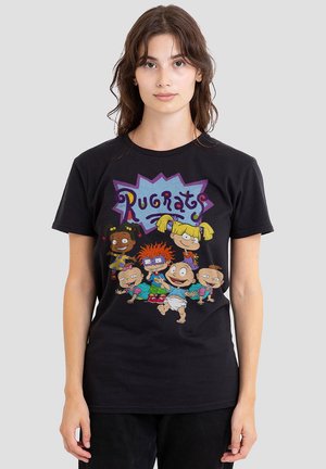 Young woman wearing black t-shirt with colorful Rugrats cartoon characters and logo on front against light gray background.