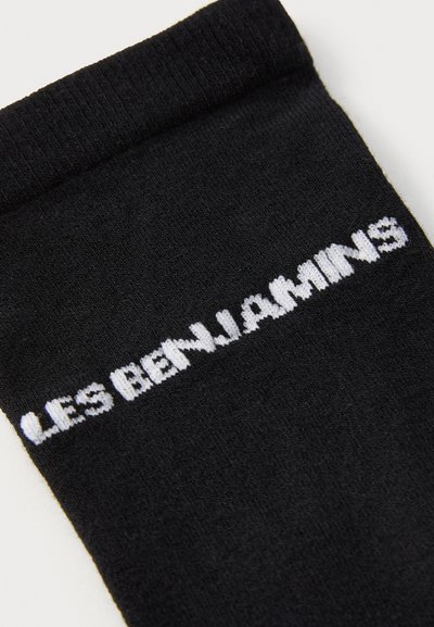 Μαύρες κάλτσες από πλεκτό ύφασμα με ραμμένο λάστιχο και λευκό κείμενο "LES BENJAMINS" πλεγμένο στο πλάι.