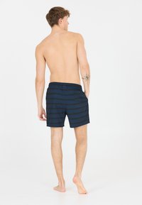 Shorts de bain rayés bleu marine en tissu léger, dotés d'une taille élastique et d'une poche au dos.