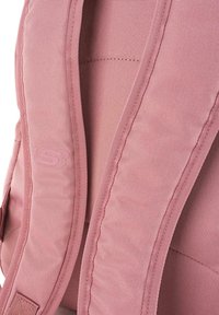 Mochila de tela rosa con tirantes acolchados, superficie texturizada y detalles de costura sutiles; logo grabado en la correa.