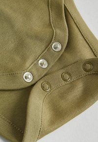 Olivengrøn bomuldsbodies med en glat tekstur, der har tre metaltrykknapper og en blød, ribbet kant ved kraven.