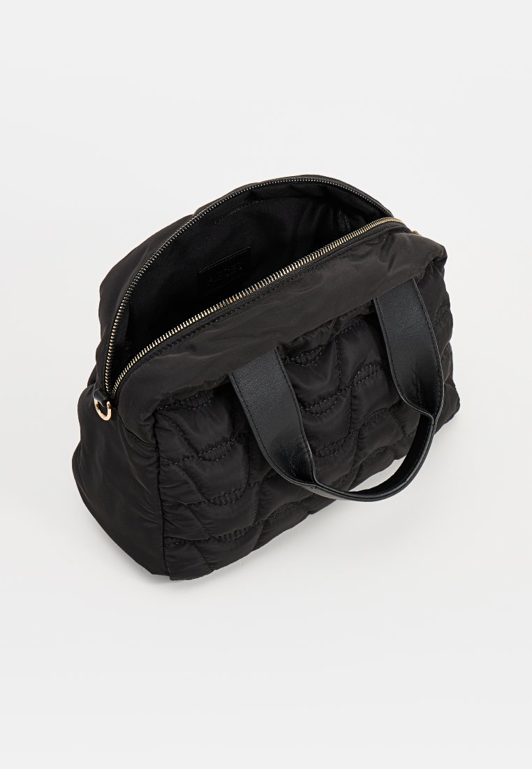 Czarna pikowana torba na ramię z materiałowym korpusem, skórzanymi uchwytami i złotym zamkiem. Otwarty górny suwak odsłania gładkie wnętrze i etykietę marki wewnątrz.