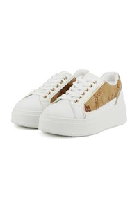 Sneakers bianchi con suola piatta e pannelli laterali marroni, caratterizzati da un design di mappa vintage e occhielli dorati, mostrati da una vista angolata frontale.