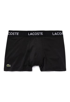 Black boxer shorts with an elastic waistband featuring "LACOSTE" in white text, adorned with a small green crocodile logo on the left side.