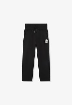 Pantalones deportivos negros con cintura ajustable mediante cordón, bolsillos laterales y un logo circular blanco en el muslo izquierdo. Fabricados con un tejido suave y texturizado.