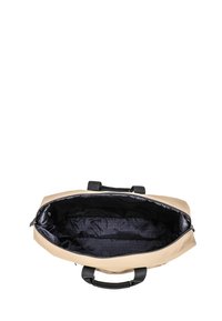 Borsa sintetica beige con manici neri. L'apertura rivela un interno scuro foderato da un motivo logo ripetuto. Chiusura superiore con zip per una maggiore sicurezza.