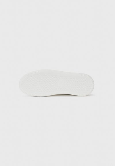 White sneaker sole featuring a textured surface with a herringbone pattern and a slightly raised heel for traction. Smooth edges.