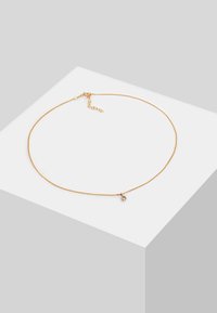 Goldene Metallkette mit einer dünnen Kette und einem kleinen diamantförmigen Anhänger. Verfügt über einen verstellbaren Verschluss für individuelle Längenanpassung.