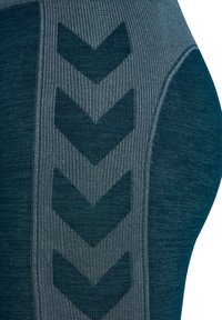 Bodywear in un tessuto di un verde scuro testurizzato con un motivo a coste. Design a zigzag grigio notevole lungo il lato.