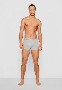 Graue Baumwollboxershorts mit körpernahem Schnitt und einem Bund, der das Calvin Klein-Logo trägt. Entworfen für eine enge Passform, mit minimalen Nähten.