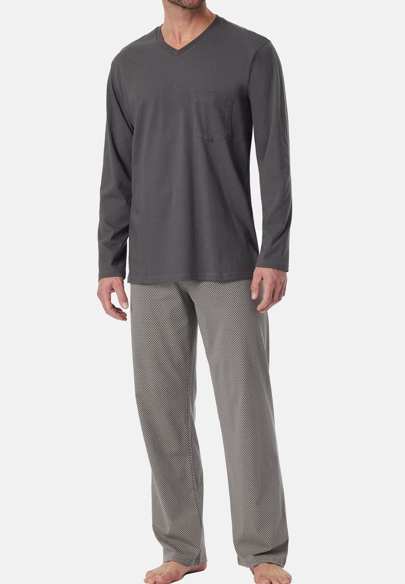 Chemise grise à manches longues en V avec une poche sur la poitrine, associée à un pantalon de pyjama léger gris à motifs. L'ensemble a une coupe décontractée.