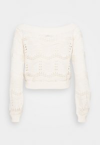 Suéter corto blanco de punto con diseño de hombros al descubierto, que presenta un patrón en ondas y un tejido texturizado, mangas largas y puños acanalados.