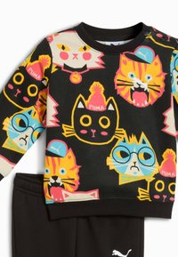 Sudadera negra con gráficos de gatos coloridos en naranja, amarillo y rosa. Tejido suave con cuello redondo y detalles en negro.