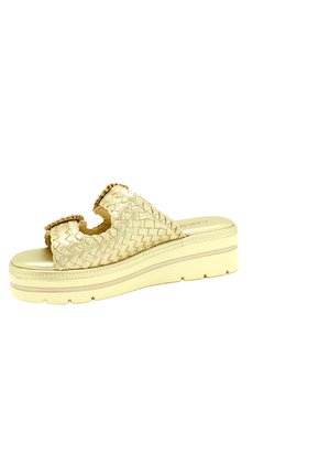 Sandalia de plataforma tejida en oro metálico, con punta abierta, diseño cortado y una suela gruesa y texturizada con una base en color amarillo claro.