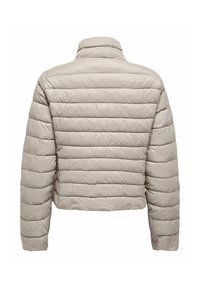 Gaišs, neilgs pūkains jaciņš bēšā krāsā. Lietojamas dūlas daļas, augsts apkakle un gluda, spīdīga tekstūra. Nav redzamu metāla detaļu.