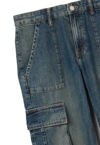 Denim cargobroek in middelblauw met een zachte, gestructureerde afwerking. Voorzien van meerdere zakken, een knoopsluiting en contrasterende stiksels.