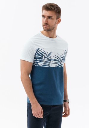 Bomulds T-shirt med en hvid øverste sektion med blå palmebladtryk og en ensfarvet marineblå nederste sektion. Korte ærmer, rund halsudskæring.