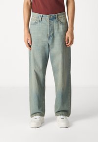 Helleblaue Jeans im entspannten Schnitt mit fünf Taschen, Knopfverschluss und subtilen Ausbleichungen im Stoff.