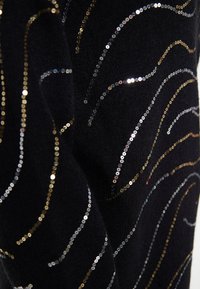 Tessuto nero decorato con motivi ondulati di paillettes metalliche nei toni oro, argento e rosa, creando texture e interesse visivo.