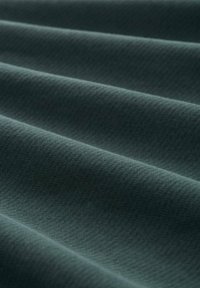 Teksturowana tkanina w stonowanym odcieniu zielonego niebieskiego, z delikatnymi, falistymi zagnieceniami, które podkreślają jej gładką powierzchnię i równomierny wzór splotu.