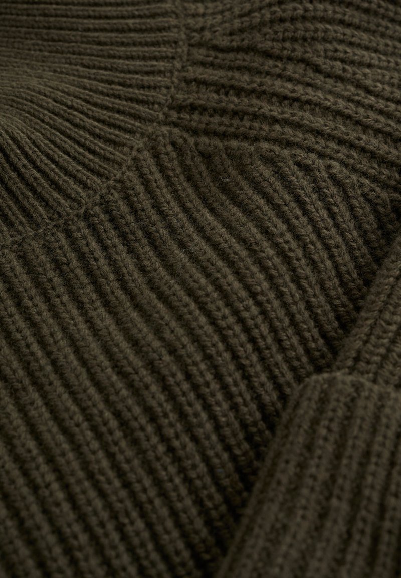 Ciemnozielony sweter dzianinowy z pionowym prążkowanym wzorem, miękką przędzą i szerokim kołnierzem. Widoczne akcenty ściegów i grube mankiety.