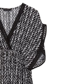 Robe à motifs noir et blanc avec un design de feuilles, présentant un décolleté en V profond, une taille froncée et des bordures en dentelle noire sur les manches.