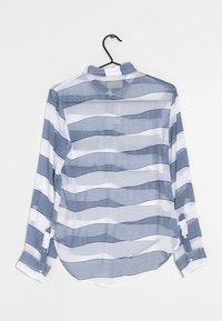 Camicia bianca a maniche lunghe con righe orizzontali blu navy, dotata di abbottonatura e polsini, realizzata in tessuto leggero e trasparente.