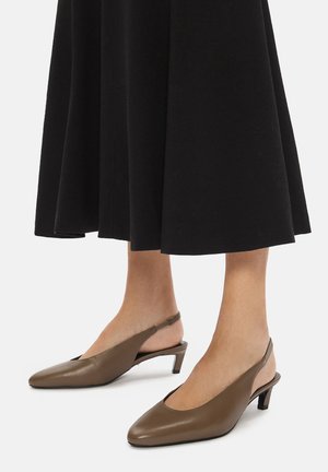 Hnedé kožené slingback topánky s špicatou špičkou a nízkym opätkom. Topánky majú hladkú textúru a minimalistický dizajn.