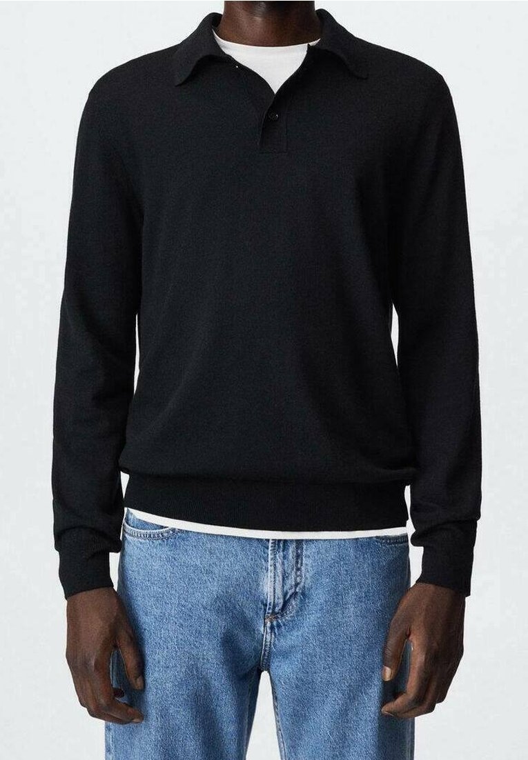 Polo à manches longues noir avec col et fermeture à boutons, présentant un ourlet ajusté et une texture douce et lisse. Porté avec un denim bleu clair.